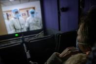 A woman watches the Chinese documentary "Days and Nights in Wuhan" following the outbreak of the coronavirus disease (COVID-19) at a cinema in Beijing