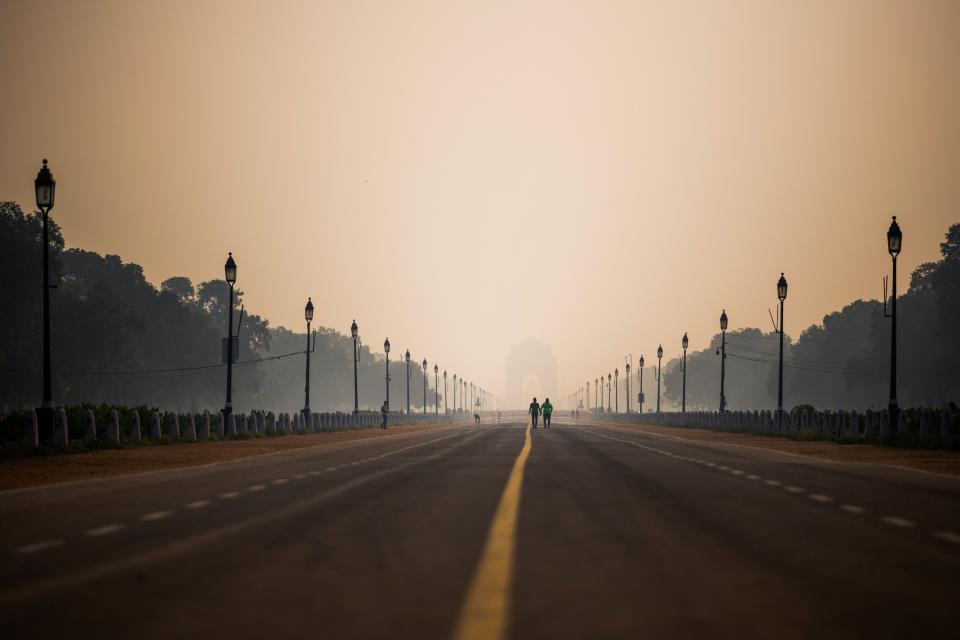 People walk along Rajpath street during a smoggy morning in New Delhi on October 15, 2020. (Photo by Jewel SAMAD / AFP) (Photo by JEWEL SAMAD/AFP via Getty Images)
