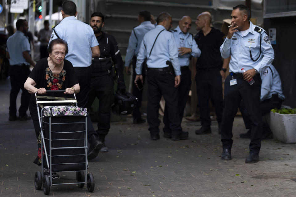 An elderly women walks next to the scene where Israeli police found the body of Palestinian Musa Sarsour after he allegedly killed an 84-year-old Israeli woman, in Tel Aviv, Israel, Wednesday, Sept. 21, 2022. Israeli police said Sarsour was found hung in central Tel Aviv after an overnight manhunt, hours after he was said to have struck and killed the woman with a heavy object in a Holon, near Tel Aviv. (AP Photo/Oded Balilty)