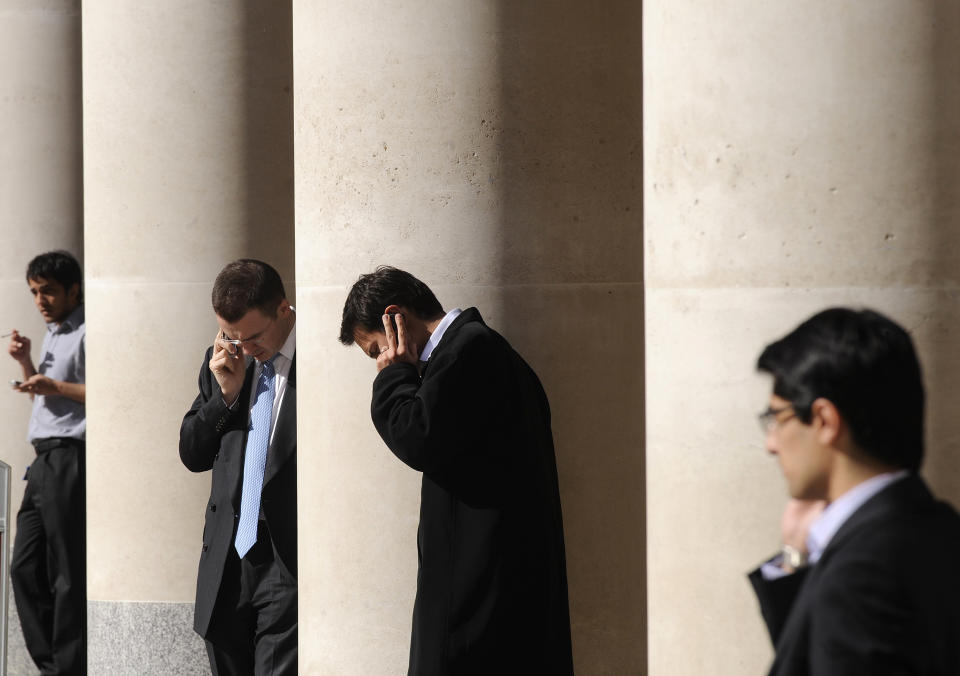 City workers make phone calls outside the London Stock Exchange in Paternoster Square in the City of London at lunchtime October 1, 2008. European policymakers have called on the U.S. Senate to approve a revised rescue plan aimed at tackling the worst financial crisis since the 1930s. REUTERS/Toby Melville (BRITAIN)