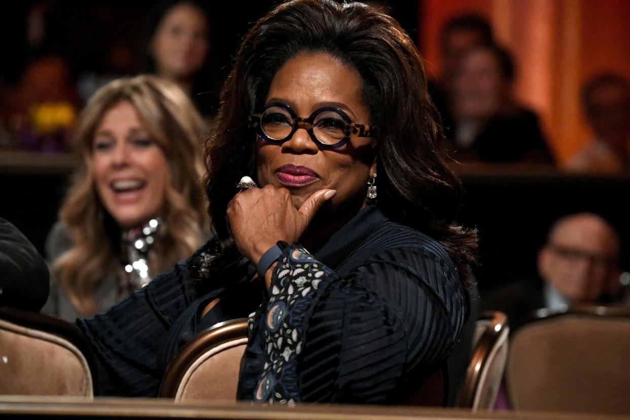 Oprah Winfrey at the the Ambassadors For Humanity Gala in round black glasses and a black top