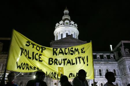 Protesters hold a sign aloft in front of City Hall during demonstrations in Baltimore, Maryland May 1, 2015. REUTERS/Lucas Jackson