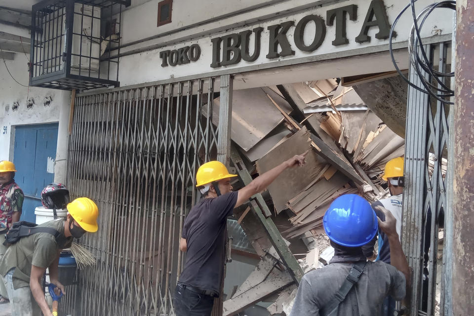 Workers inspect a store damaged during an earthquake in Cianjur, West Java, Indonesia, Monday, Nov. 21, 2022. An earthquake shook Indonesia’s main island of Java on Monday, killing a number of people, damaging dozens of buildings and sending residents into the capital's streets for safety. (AP Photo/Firman Taqur)