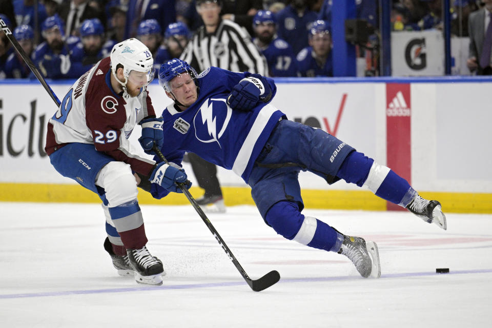 Colorado Avalanche center Nathan MacKinnon (29) checks Tampa Bay Lightning left wing Ondrej Palat (18) during the first period of Game 6 of the NHL hockey Stanley Cup Finals on Sunday, June 26, 2022, in Tampa, Fla. (AP Photo/Phelan Ebenhack)