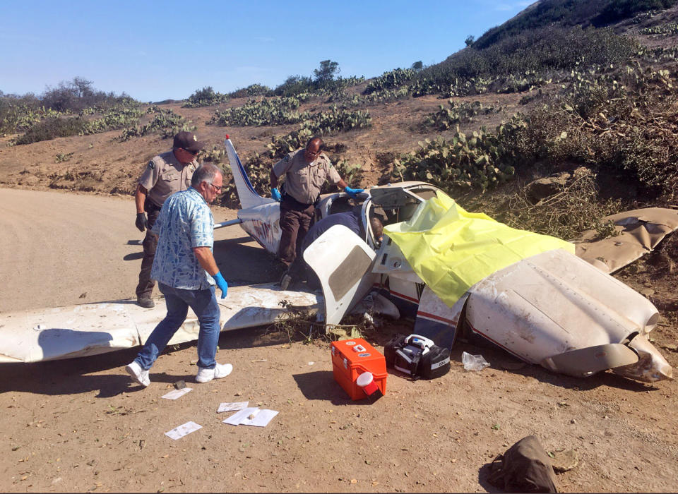 This photo provided by the Los Angeles County Sheriff's Department shows first responders examining the scene of a plane crash at the airport near Avalon on Santa Catalina Island off the Southern California coast Wednesday, July 25, 2018. Three people were injured, one severely in the 9:30 a.m. crash. The single-engine Piper PA-32 went off the runway after landing, FAA spokesman Ian Gregor said. (Los Angeles County Sheriff's Department via AP)