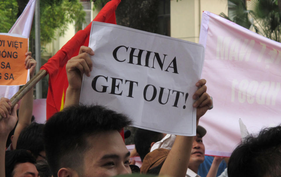 A Vietnamese protester holds a banner in a rally against Beijing's deployment of an oil rig in the contested waters of the South China Sea, outside the Chinese Embassy on Sunday, May 11, 2014 in Hanoi, Vietnam. The deployment of the rig has a triggered a tense standoff in the ocean and raised fears of confrontation between the neighboring countries. (AP Photo/Chris Brummitt)