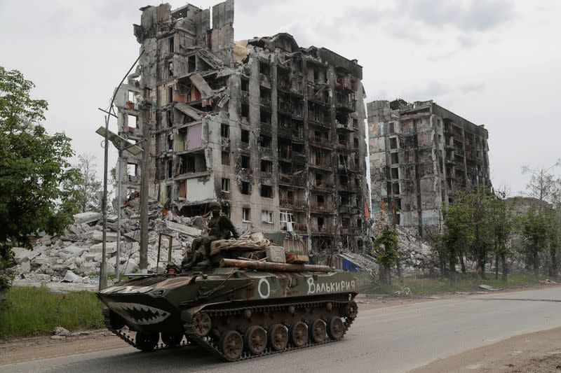 Service members of pro-Russian troops drive an armoured vehicle in Popasna