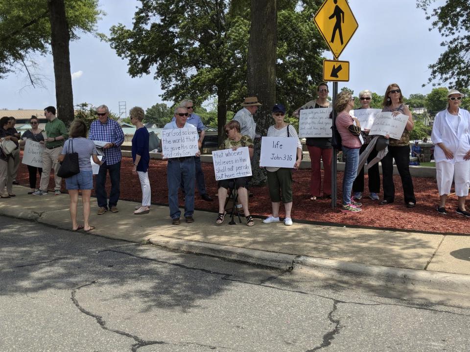 <span class="caption">People hold signs with Bible verses to protest The Satanic Temple’s unveiling of its statue of winged-goat creature Baphomet in Little Rock, Arkansas in August 2018.</span> <span class="attribution"><a class="link " href="http://www.apimages.com/metadata/Index/Satanic-Temple/7a03f273430f40a694770d925c07b6e8/4/0" rel="nofollow noopener" target="_blank" data-ylk="slk:AP Photo/Hannah Grabenstein;elm:context_link;itc:0;sec:content-canvas">AP Photo/Hannah Grabenstein</a></span>