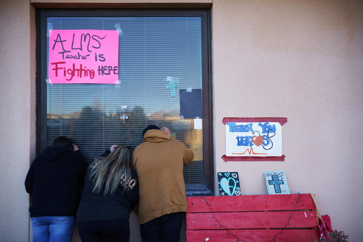 Sonja Salaiz, Monica Garcia and Dominic Garcia look through the hospital window of their aunt and grandmother Sylvia Garcia, 60, while she is intubated and sedated during a surge of coronavirus disease (COVID-19) cases at Memorial Medical Center in Las Cruces, New Mexico, U.S. November 28, 2020.  REUTERS/Paul Ratje     TPX IMAGES OF THE DAY