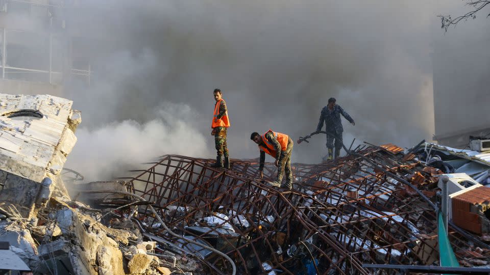 Emergency personnel extinguish a fire at the site of strikes, which hit a building next to the Iranian embassy in Syria's capital Damascus, on April 1, 2024. - Louai Beshara/AFP/Getty Images