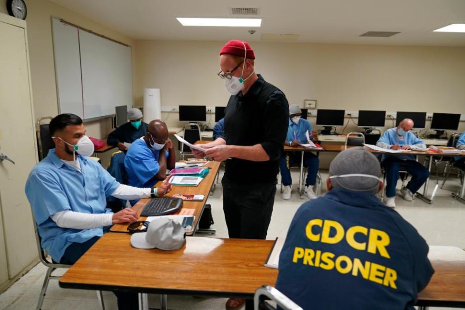 Instructor Douglas Arnwine hands back papers with comments to his students at San Quentin state prison in April 2022.