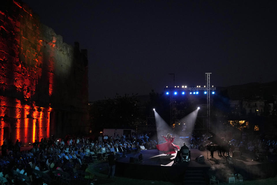 French Pianist Simon Ghraichy performs next to French-Iranian dancer Rana Gorgani during a concert in the ancient northeastern city of Baalbek, Lebanon, Sunday, July 17, 2022. Lebanon's renowned Baalbek Festival is back, held in front of a live audience for the first time in two years amid an ongoing economic meltdown. (AP Photo/Hassan Ammar)