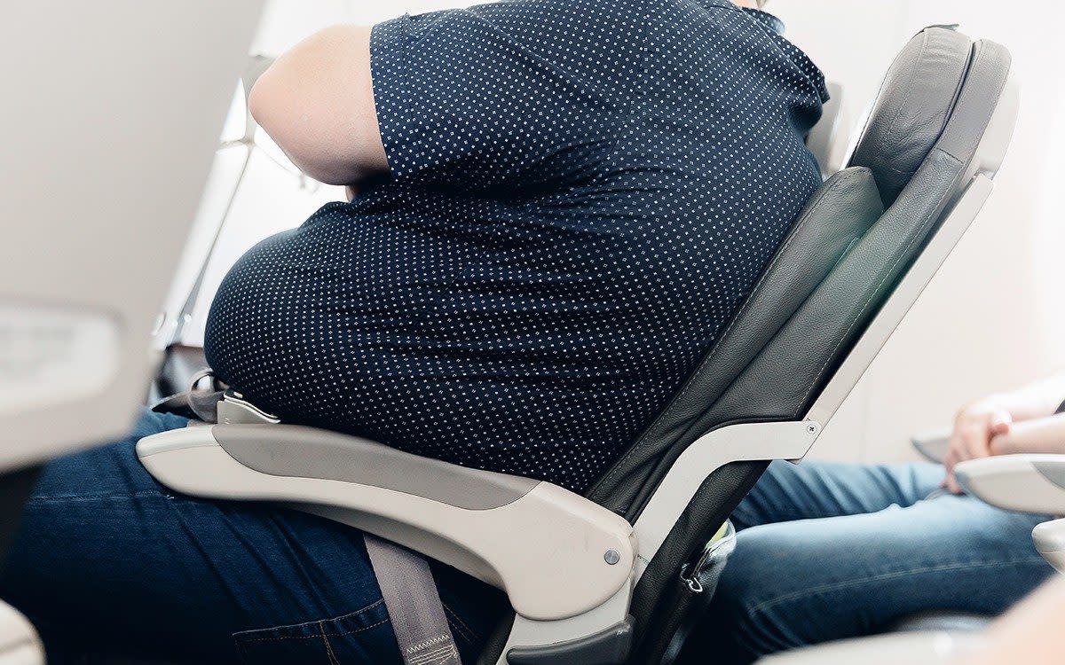 Overweight man in plane seat