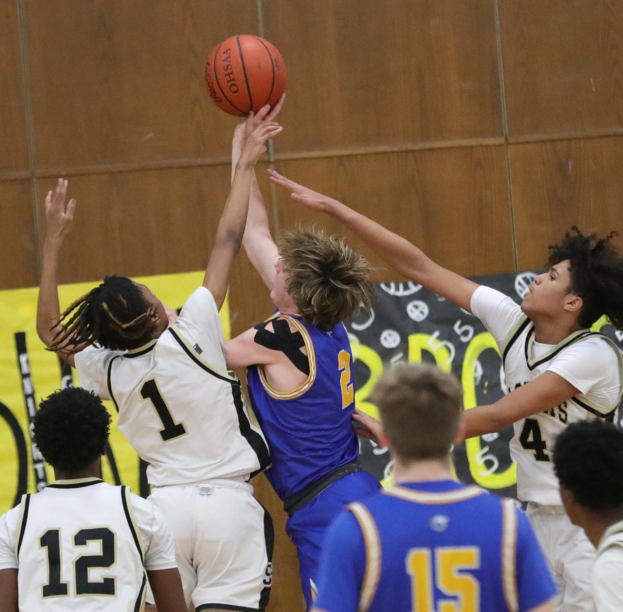 Lake Center's Matt Warder, center, puts up a shot defended by St. Thomas Aquinas' Jordan Thomas, left, and Mason Welch, right, Friday, Feb. 16, 2024.