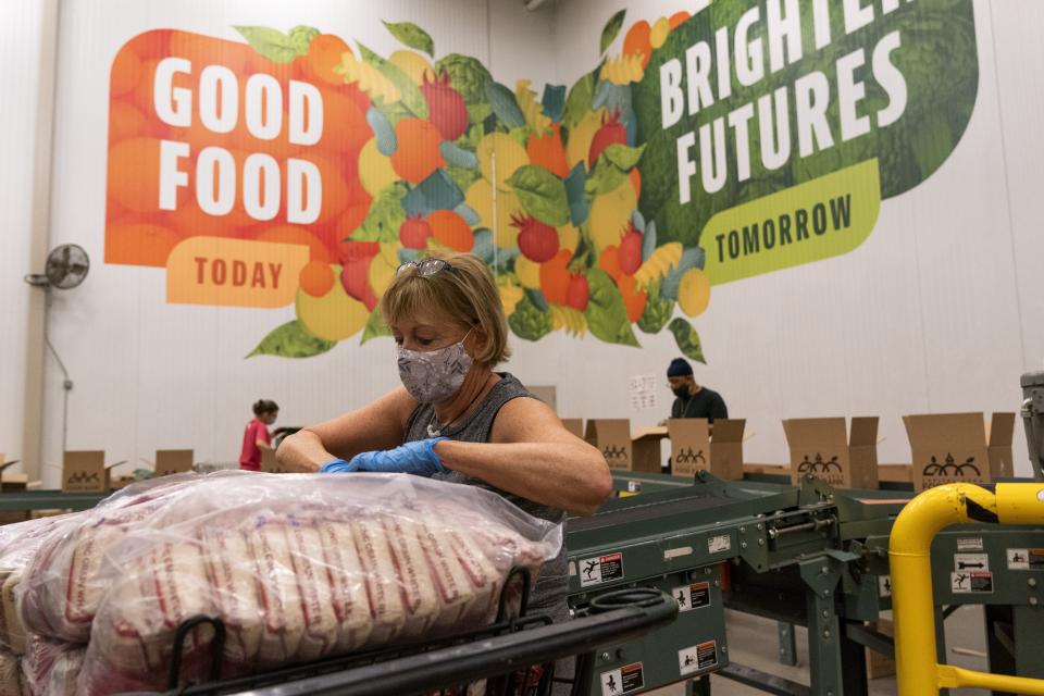 Volunteers pack boxes of food for distribution, at The Capital Area Food Bank, Tuesday, Oct. 5, 2021, in Washington. (AP Photo/Jacquelyn Martin)