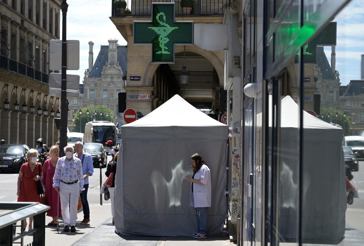 A medical staff smokes near a curbside testing tent placed in front of a pharmacy, in Paris, on June 29, 2022. - The seventh wave of the Covid epidemic is accelerating in France and the recommendations to put the mask back on, particularly in transport, are multiplying on the part of the government, without any certainty that they will be enough, along with vaccination, to curb the movement (Photo by AFP) (Photo by -/AFP via Getty Images)