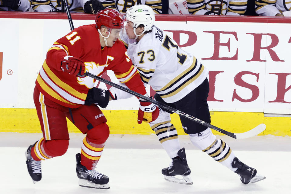 Boston Bruins' Charlie McAvoy, right, runs into Calgary Flames' Mikael Backlund during the second period of an NHL hockey game Thursday, Feb. 22, 2024, in Calgary, Alberta. (Larry MacDougal/The Canadian Press via AP)