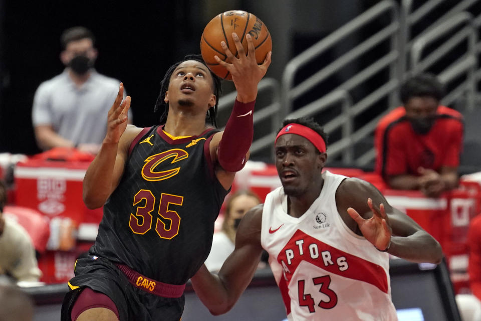 Cleveland Cavaliers forward Isaac Okoro (35) goes for a layup after driving around Toronto Raptors forward Pascal Siakam (43) during the second half of an NBA basketball game Monday, April 26, 2021, in Tampa, Fla. (AP Photo/Chris O'Meara)
