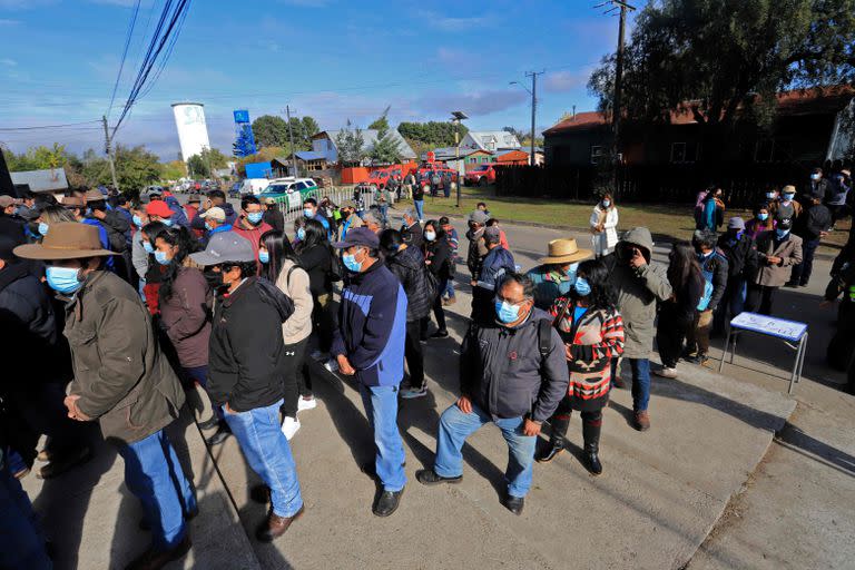 Trabajadores rurales chilenos aguardan en fila para votar en Temuco