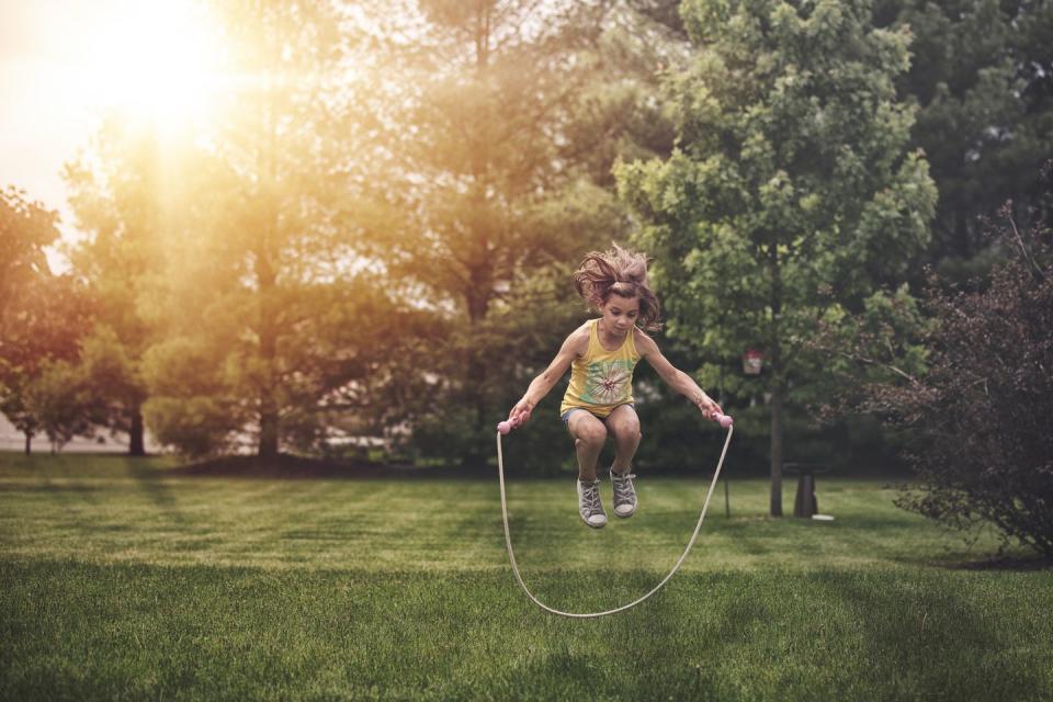 summer activities girl caught mid air jumping rope