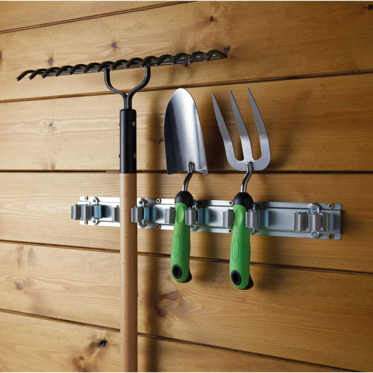  Garden tool holder storing tools in shed. 