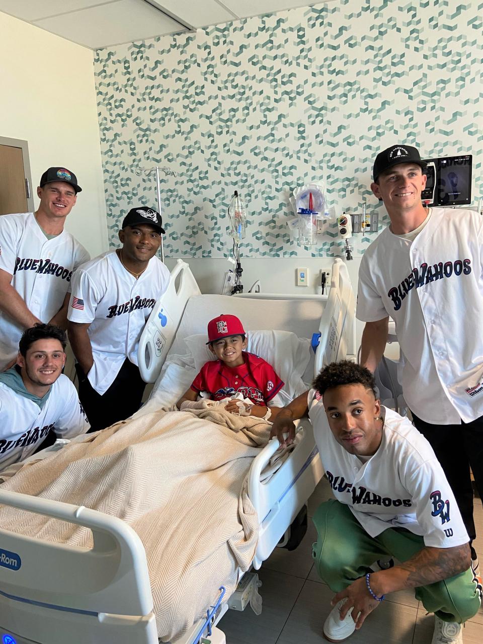 Blue Wahoos players greet a young patient wearing his baseball uniform during a recent visit to HCA Florida West Hospital on Davis Highway