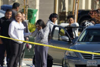 Neighbors react near a home where five bodies were found in the city of Lancaster in the high desert Antelope Valley north of Los Angeles, Monday, Nov. 29, 2021. A Los Angeles County Sheriff's Department statement says deputies found a woman, a girl and three boys with gunshot wounds and paramedics pronounced them dead at the scene. The department says the children's father showed up at the Lancaster sheriff's station and was arrested on suspicion of five murders after being interviewed by detectives. (AP Photo/Ringo H.W. Chiu)