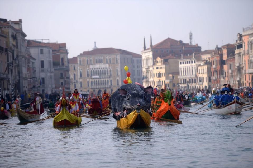 <p>Bright coloured boats filled with costumed revellers move along Venice, Italy’s Grand Canal during the opening regatta of the Venice Carnival on January 28, 2018. Photo by Filippo Monteforte/AFP/Getty Images. </p>