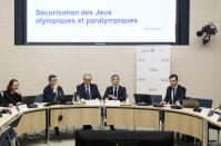 French Interior Minister Gerald Darmanin sits between lawmakers as he attends an Olympics security hearing at the Senate in Paris, Tuesday, March 5, 2024. The French government announced that tourists won't be allowed to watch the opening ceremony of the Paris Olympics for free as initially promised, the government announced Tuesday, as it grapples with security concerns about the unprecedented open-air event along the Seine River. Screen reads, Olympic and Paralympic security. (AP Photo/Thomas Padilla)