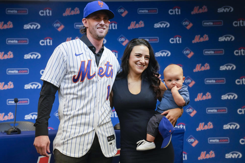 New York Mets' Jeff McNeil, left, poses for photographers with his wife Tatiana and son Lucas during a news conference, Tuesday, Jan. 31, 2023, in New York. Batting champion Jeff McNeil and the New York Mets finalized a $50 million, four-year contract Tuesday that avoided a salary arbitration hearing.(AP Photo/Mary Altaffer)