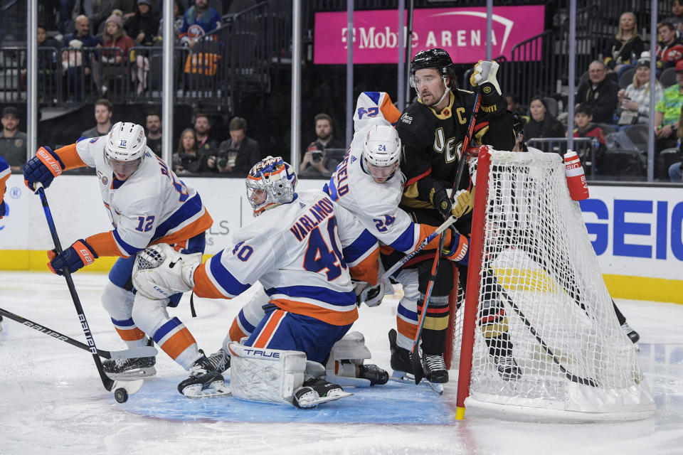 New York Islanders right wing Josh Bailey (12) helps clear the puck out of the crease during the second period of an NHL hockey game against the Vegas Golden Knights Saturday, Dec. 17, 2022, in Las Vegas. (AP Photo/Sam Morris)