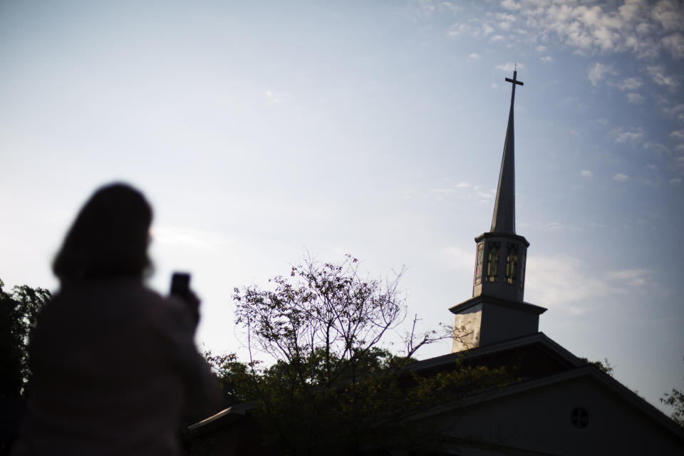 Susan Williams, of Tallahassee, Fla., takes a photo before entering Maranatha Baptist Church for Sunday School class by former President Jimmy Carter on Aug. 23, 2015, in Plains, Ga. (AP Photo/David Goldman)