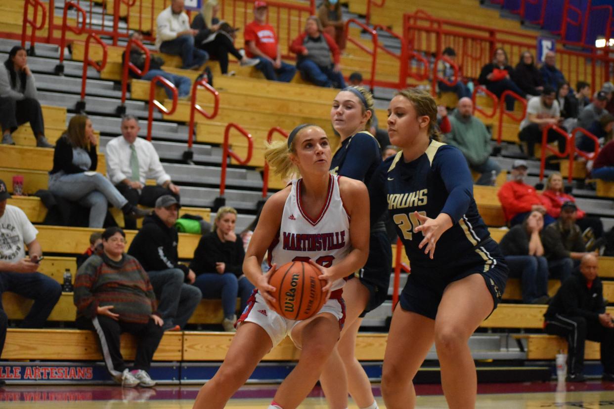 Martinsville senior Delaney Wolfe drives the baseline in search of a layup as Decatur Central's Aliseonna Garnett (24) and Jazlynn Stewart close in during their game on Jan. 19, 2022.