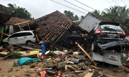 A resident searches for items among the ruins of a villa after the area was hit by a tsunami, at Carita beach in Padeglang, Banten province, Indonesia, Decemnber 23, 2018 in this photo taken by Antara Foto. Antara Foto/Asep Fathulrahman/ via REUTERS