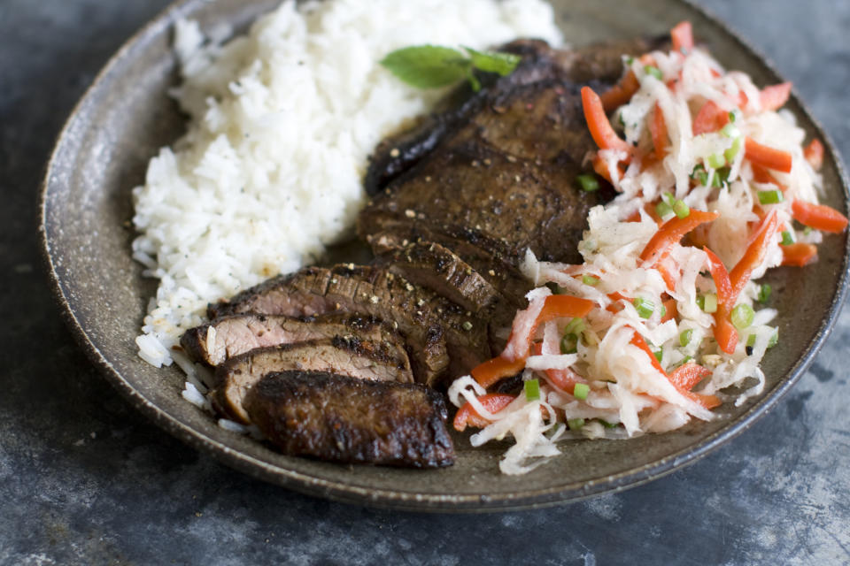 This Dec. 2, 2013 photo shows pan seared flank steak with daikon slaw in Concord, N.H. Daikon radish resemble giant white carrots, but have a mild peppery bite. (AP Photo/Matthew Mead)