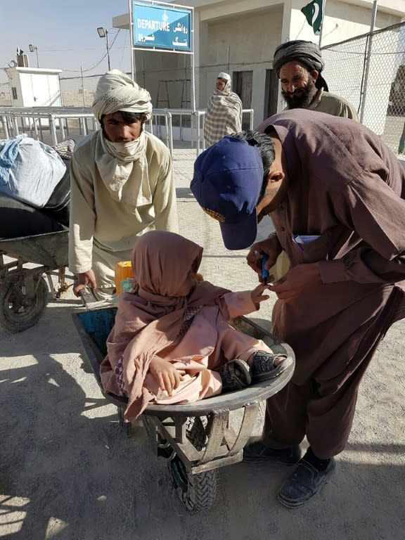 A young traveller has their finger marked by an official as they wait to cross the border between Pakistan and Afghanistan at Chaman -- one of just two major border crossings