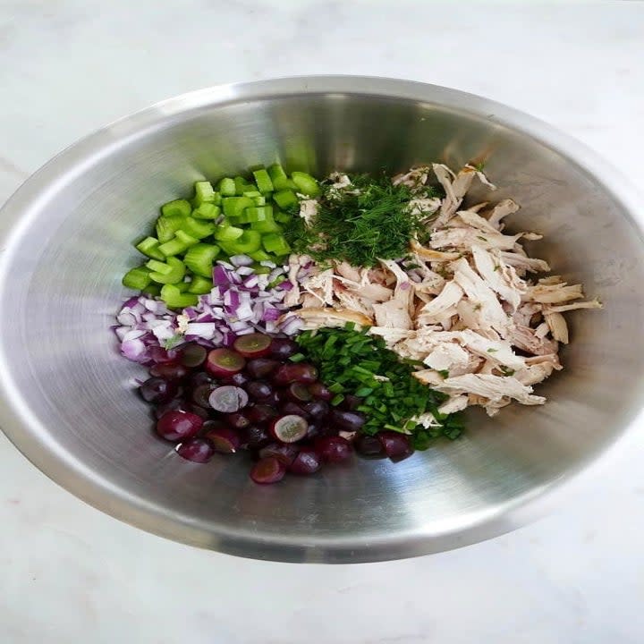 Ingredients for rotisserie chicken salad in a mixing bowl.