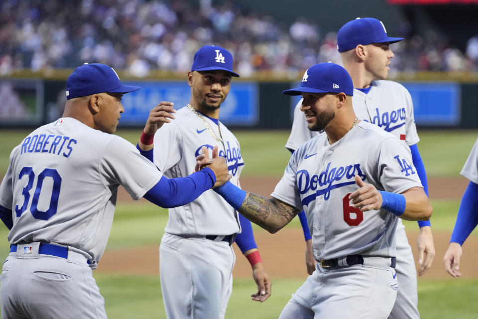 El mánager de los Dodgers de Los Ángeles Dave Roberts (30) saluda a David Peralta junto a Mookie Betts y Freddie Freeman antes del juego ante los Diamondbacks de Arizona el 6 de abril del 2023. (AP Foto/Ross D. Franklin)