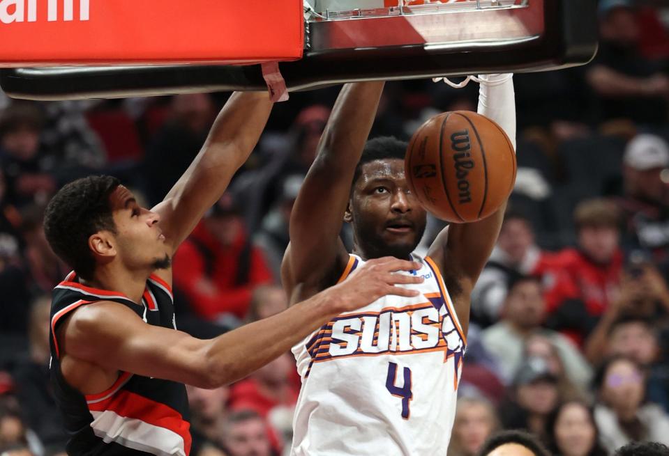 Jan 14, 2024; Portland, Oregon, USA; Phoenix Suns forward Chimezie Metu (4) dunks the ball over Portland Trail Blazers forward Kris Murray (8) in the second quarter at Moda Center.