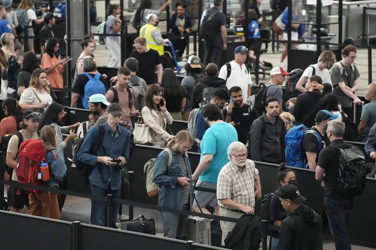 Viajeros hacen largas filas en un punto de revisión, el martes 5 de julio de 2022, en el Aeropuerto Internacional de Denver. (AP Foto/David Zalubowski)