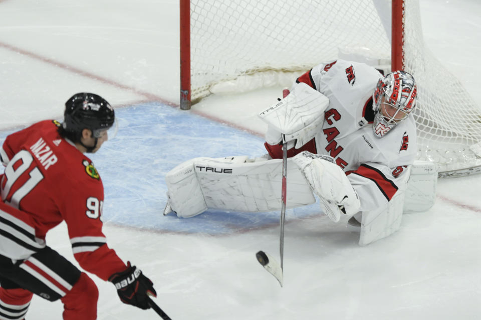 Carolina Hurricanes goalie Pyotr Kochetkov clears the puck from the goal against Chicago Blackhawks' Frank Nazar during the second period of an NHL hockey game, Sunday, April 14, 2024, in Chicago. (AP Photo/Paul Beaty)