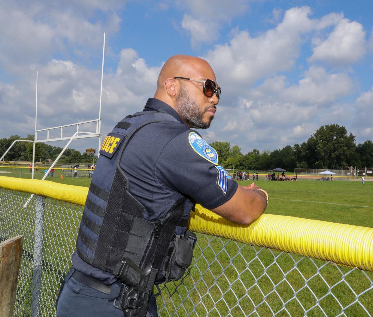Akron Police Sgt. Mike Murphy Jr. provides security during Sunday's pee wee football games at Erie Island Park.