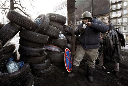 An anti-government protester has his lunch by a barricade at the site of clashes with riot police in Kiev January 27, 2014. REUTERS/Vasily Fedosenko