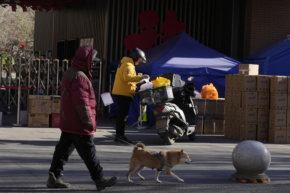 A delivery man drops off an order outside an old folks home in Beijing, Friday, Dec. 16, 2022. A week after China dramatically eased some of the world's strictest COVID-19 containment measures, uncertainty remained Thursday over the direction of the pandemic in the world's most populous nation. (AP Photo/Ng Han Guan)