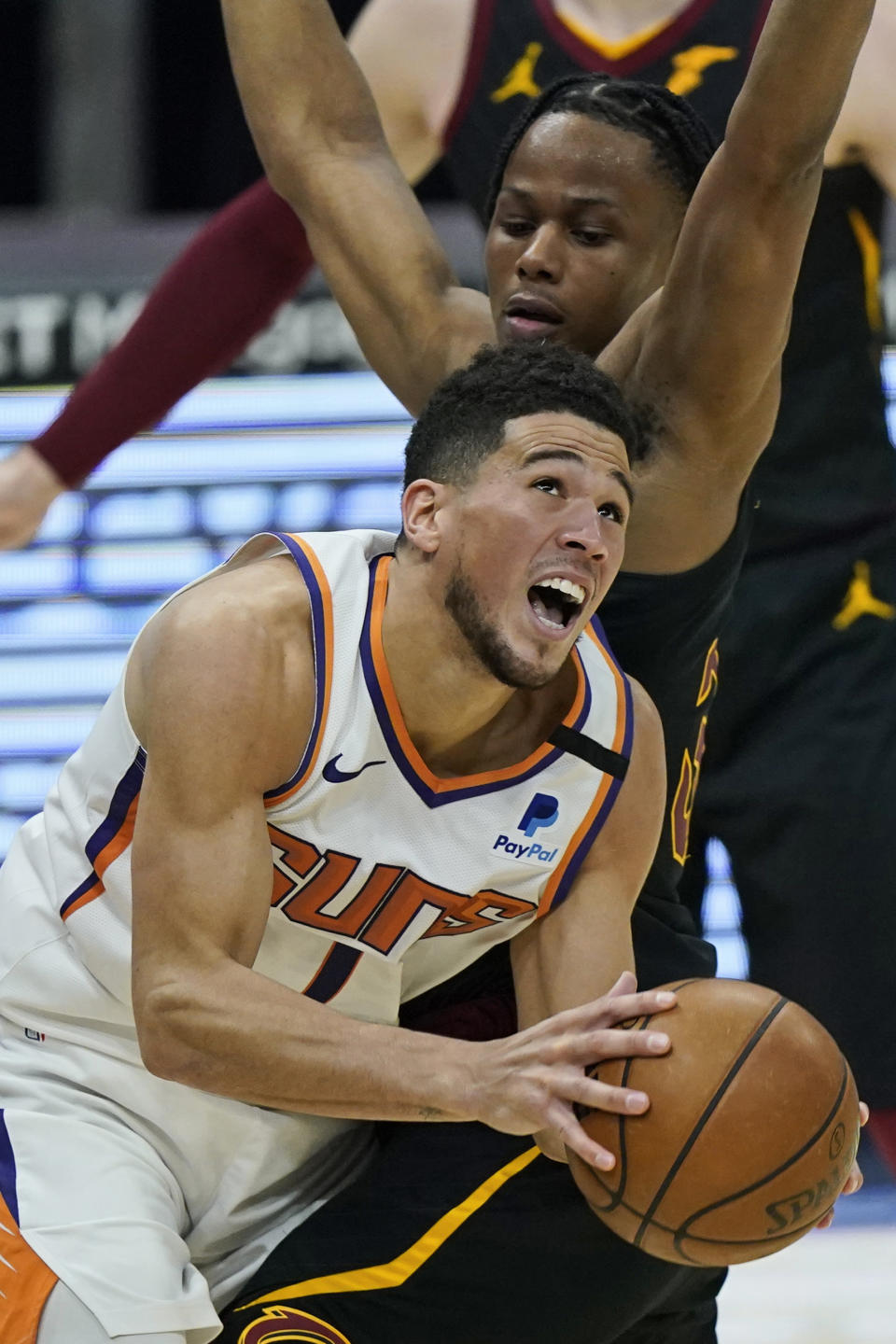 Phoenix Suns' Devin Booker (1) drives against Cleveland Cavaliers' Isaac Okoro (35) in the first half of an NBA basketball game, Tuesday, May 4, 2021, in Cleveland. (AP Photo/Tony Dejak)