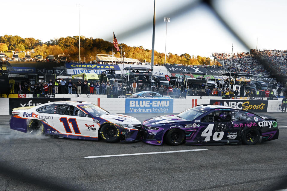 Denny Hamlin (11) prevents Alex Bowman (48) from doing a celebratory burnout after a NASCAR Cup Series auto race, Sunday, Oct. 31, 2021, in Martinsville, Va. (AP Photo/Wade Payne)