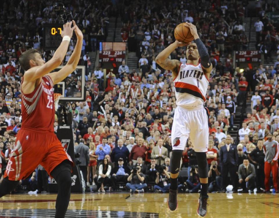 Portland Trail Blazers' Damian Lillard (0) shoots his winning shot against the Houston Rockets during the last .9 of a second of game six of an NBA basketball first-round playoff series game in Portland, Ore., Friday May 2, 2014. The Trail Blazers won the series in a 99-98 win. (AP Photo/Greg Wahl-Stephens)