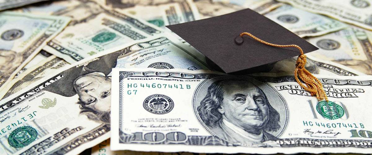 mini graduation cap on US money -- education costs