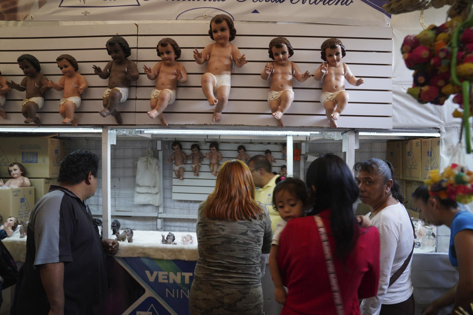 Locals buy Baby Jesus figures in Mexico City, Wednesday, Jan. 25, 2023. As Mexicans prepare to celebrate "Dia de la Candelaria" or Candlemas people buy Baby Jesus figures as part of the celebration. (AP Photo/Marco Ugarte)