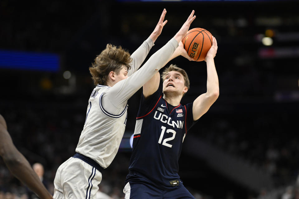 Connecticut guard Cam Spencer (12) looks to the basket against Georgetown guard Rowan Brumbaugh (1) during the first half of an NCAA college basketball game, Saturday, Feb. 10, 2024, in Washington. (AP Photo/Nick Wass)